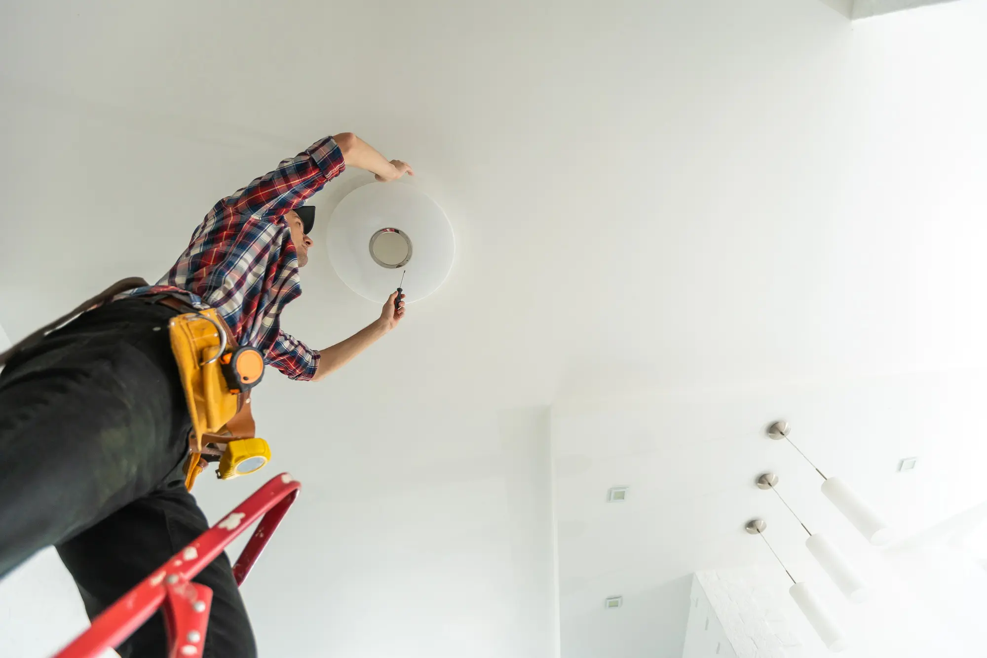 Electrician installer with a tool in his hands, working with cable on the construction site. Repair - CEC Electric / CEC Instruments Electrician installer with a tool in his hands, working with cable on the construction site. Repair